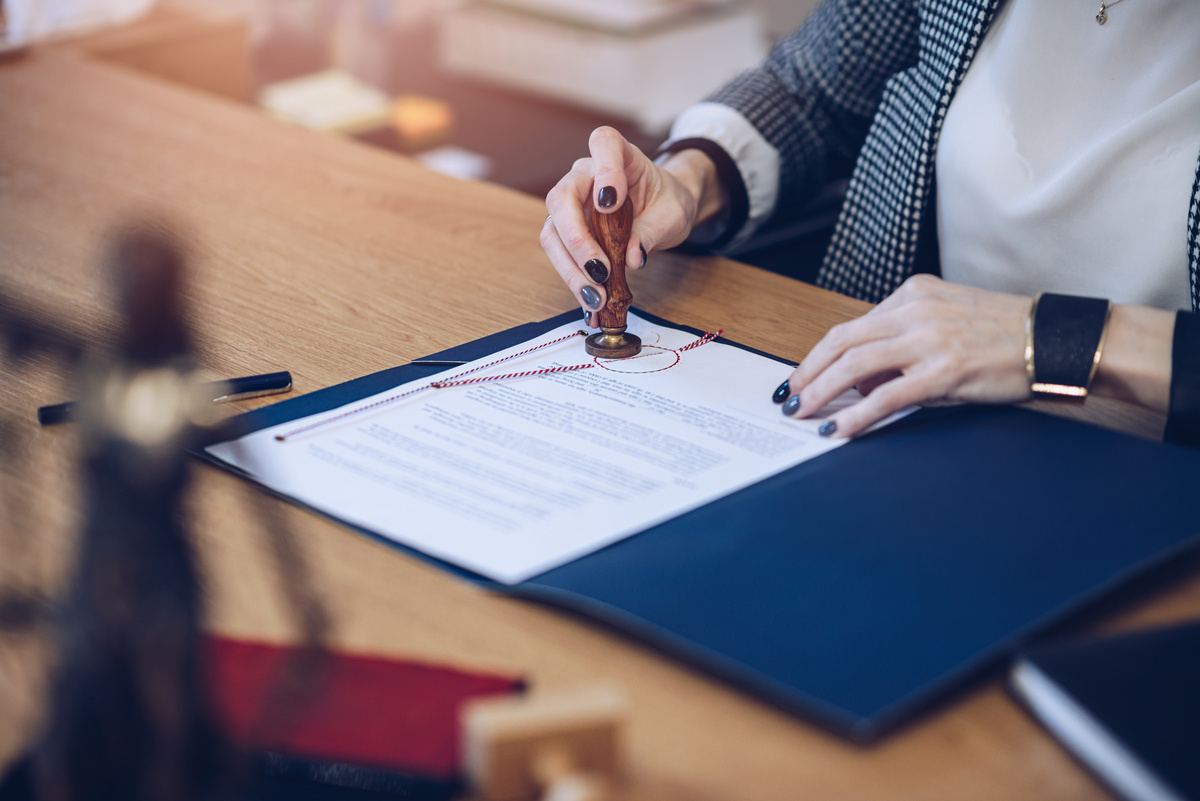 A woman notary, a lawyer stamps the seal on the notarial act.